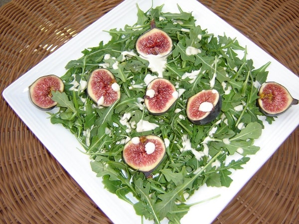Arugula with Black Mission Figs in a white plate - vegan recipes salads